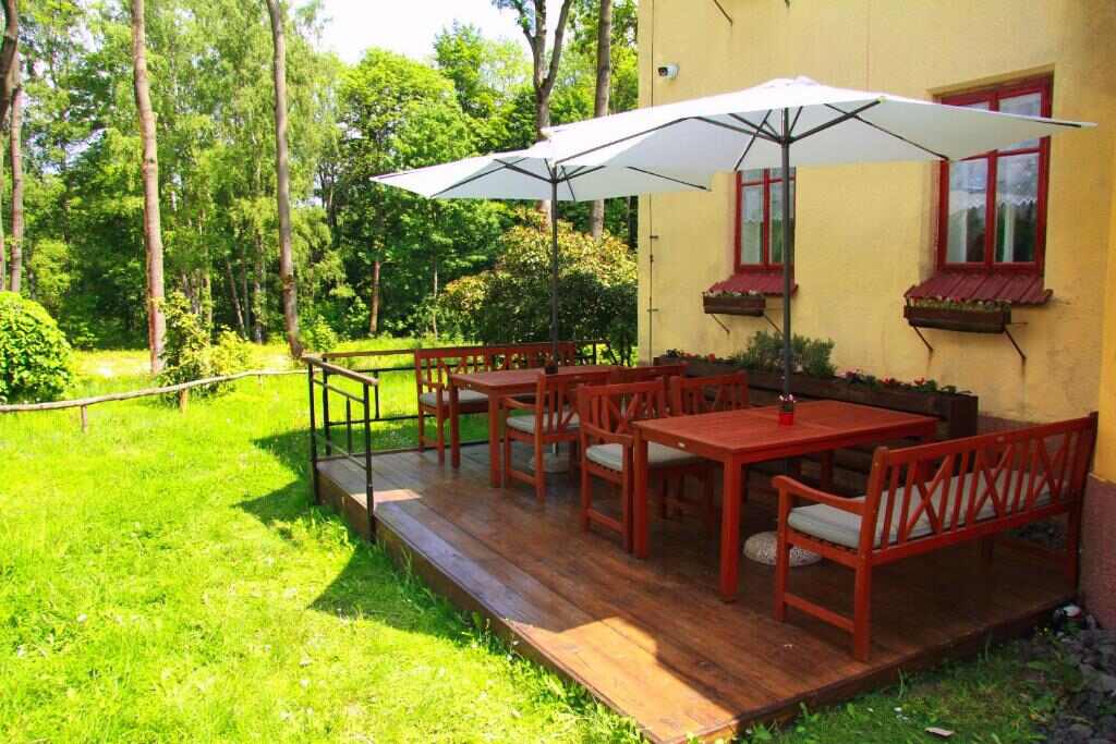 Wooden terrace with garden furniture beside the villa